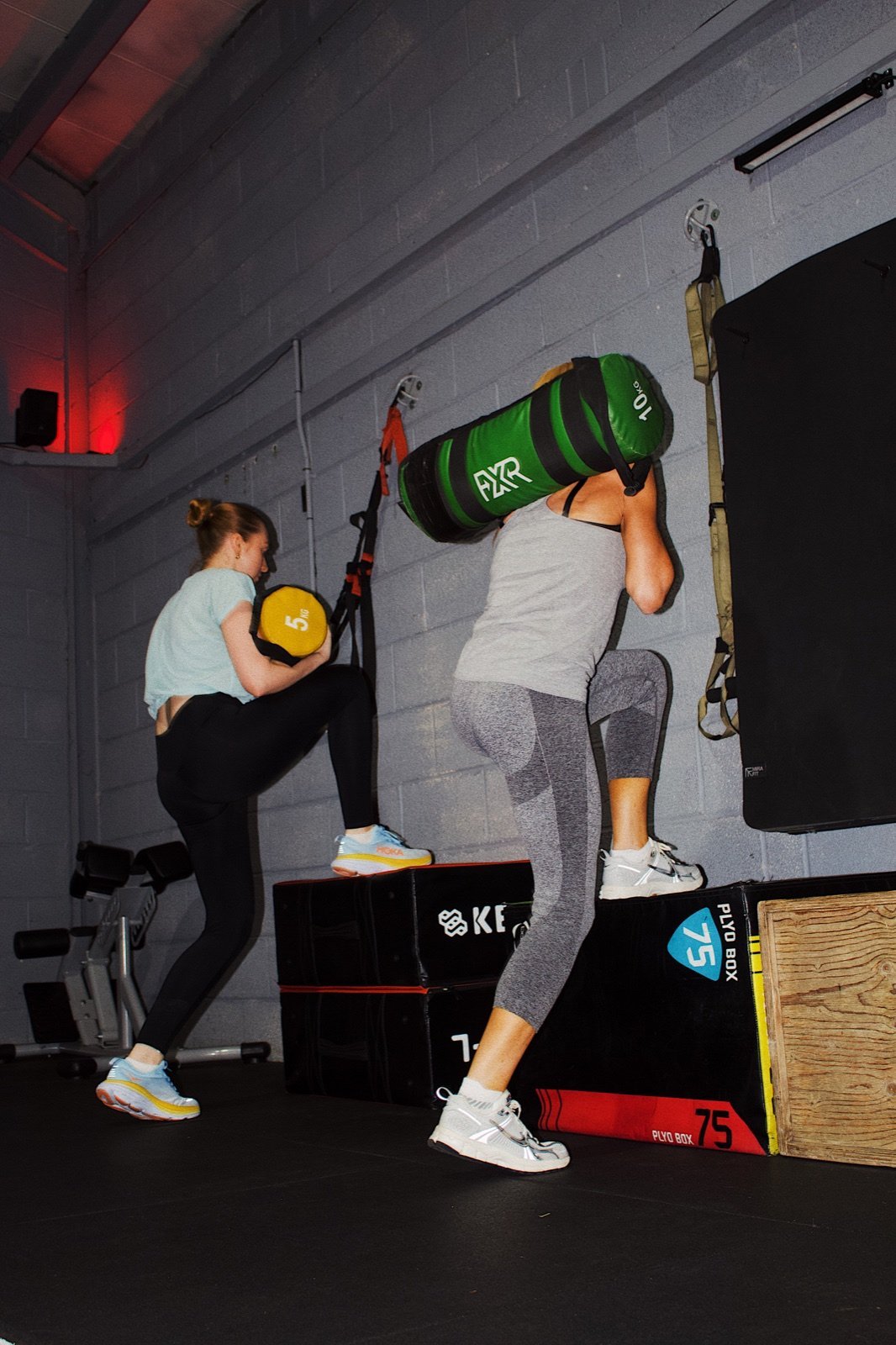 Members performing weighted step-ups during a GymSpace class